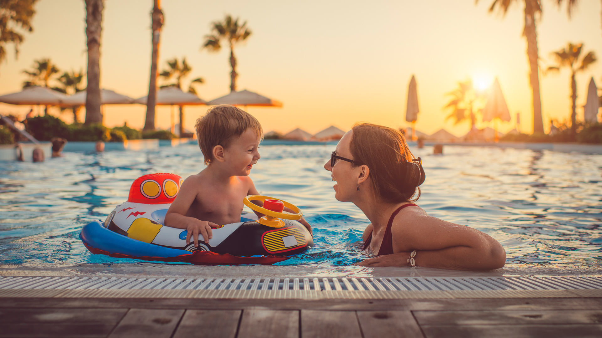 https://cdn.gobankingrates.com/wp-content/uploads/2019/04/family-fun-on-summer-vacation-in-hotel-pool-iStock-1136247293.jpg