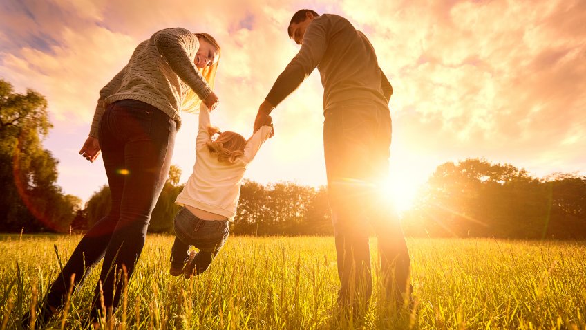 Happy family in the park evening light.