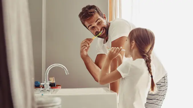 father and daughter brushing teeth in remodeled bathroom
