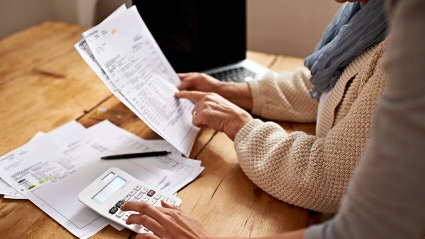 Cropped view of a senior woman receiving help with her finances from her granddaughter.