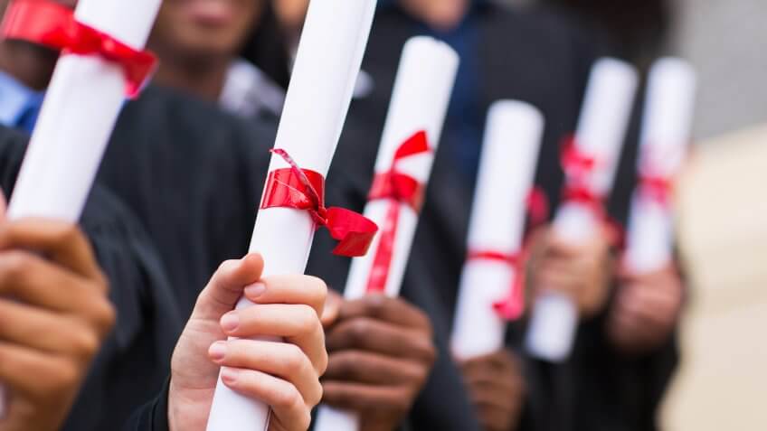 group of multiracial graduates holding diploma.
