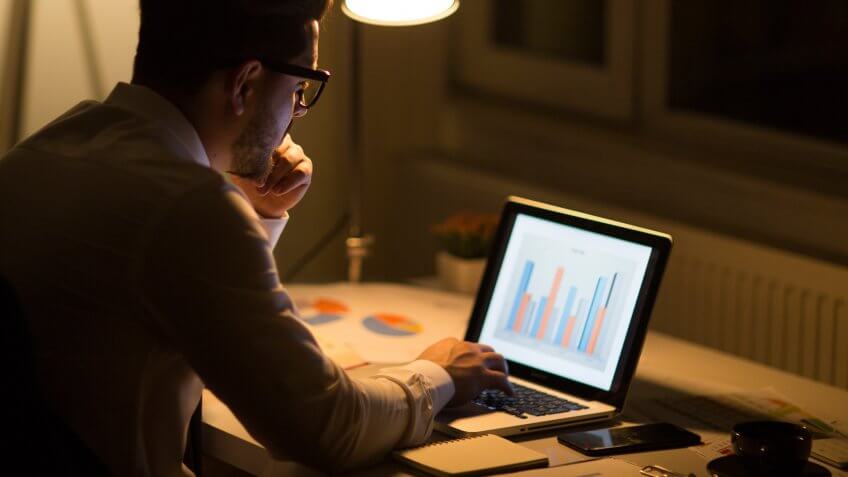 Man working with laptop late at night at home.