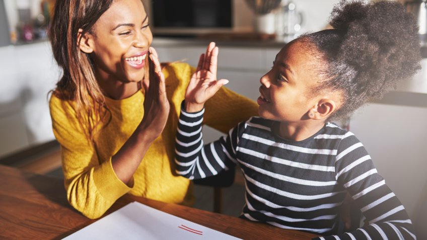 Learning to calculate, high five success, black mother and child.