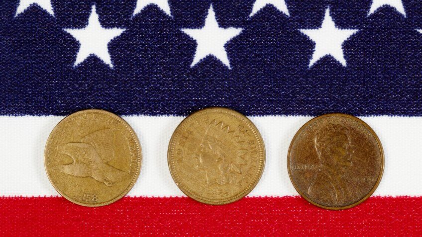 Closeup view of United States One Cent Pieces, original start dates, placed on American Flag.