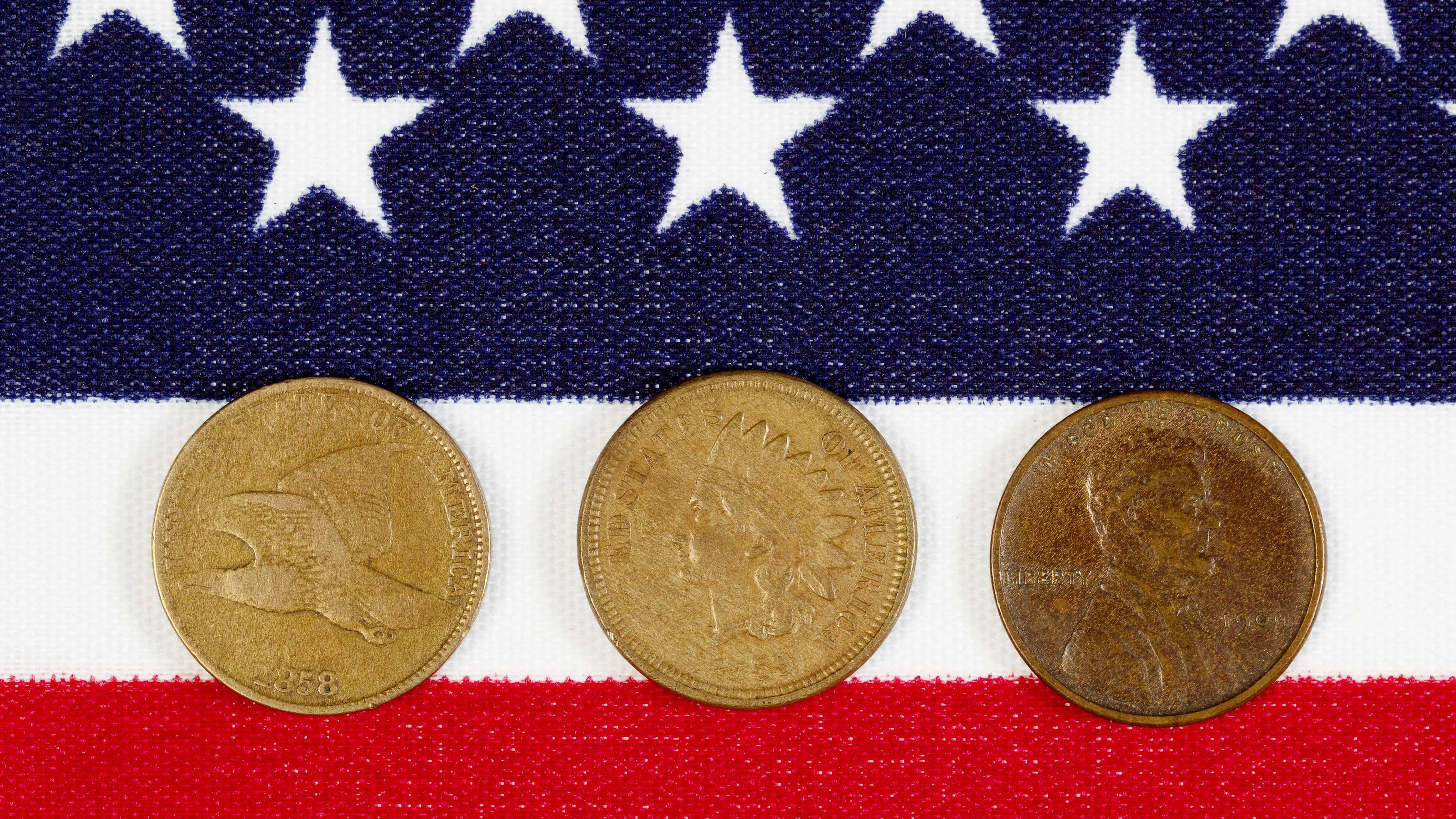 Closeup view of United States One Cent Pieces, original start dates, placed on American Flag.