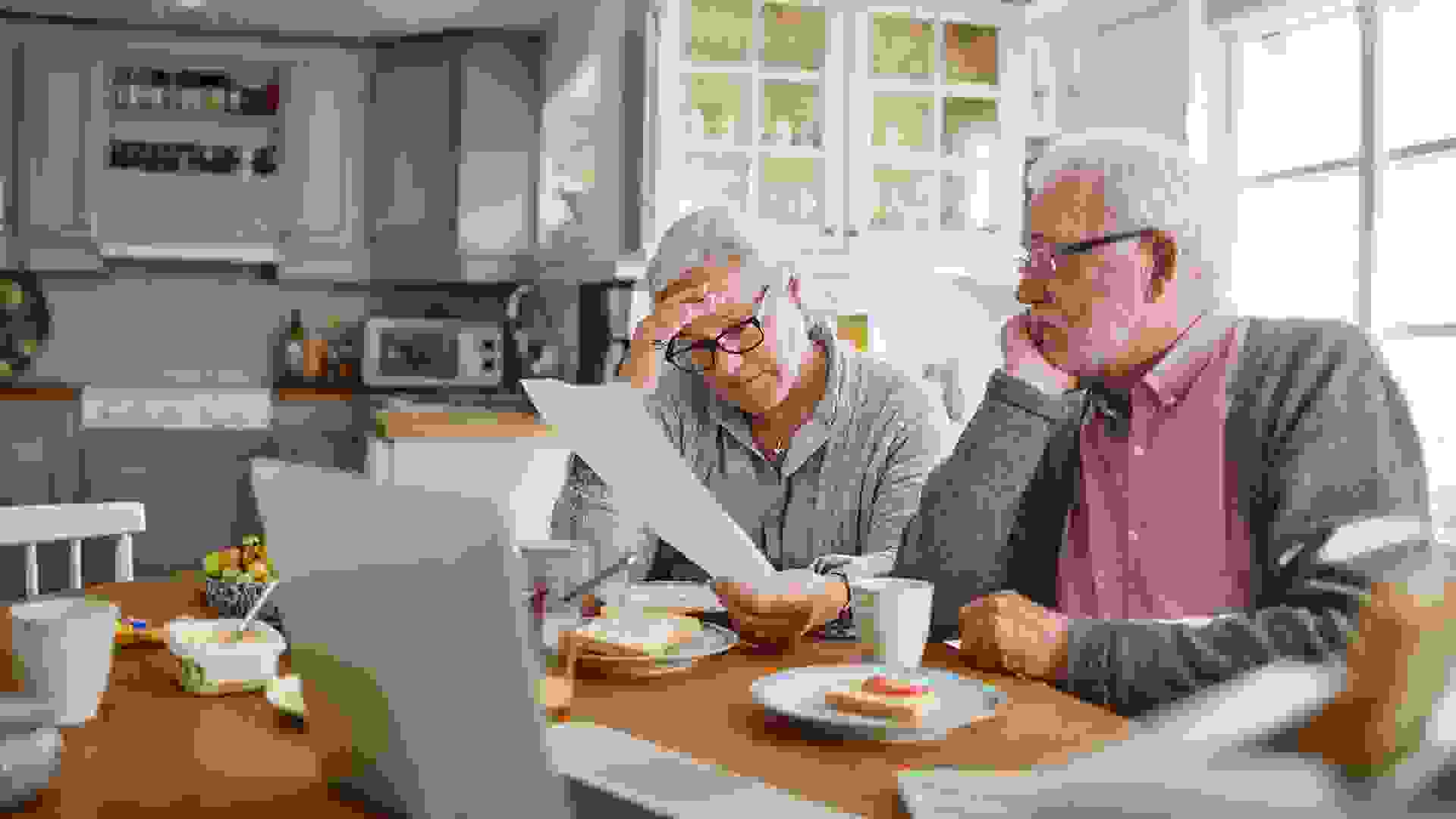 Close up of a senior couple having breakfast and doing bills.
