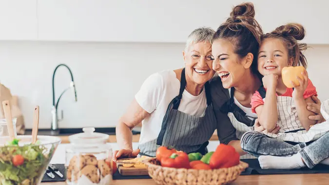 Three-generation women - grandmother, mother and small girl having fun in the kitchen, with copy space.