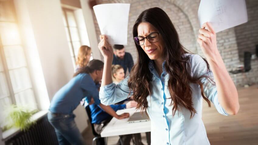 Picture of angry overworked businesswoman in modern office.