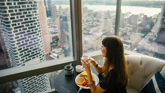 Women have breakfast by amazing city view.