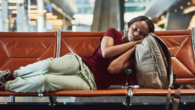 Shot of a young woman falling asleep at the airport while waiting for departure.