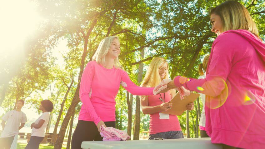 Diverse group of women are dressed in pink clothing.