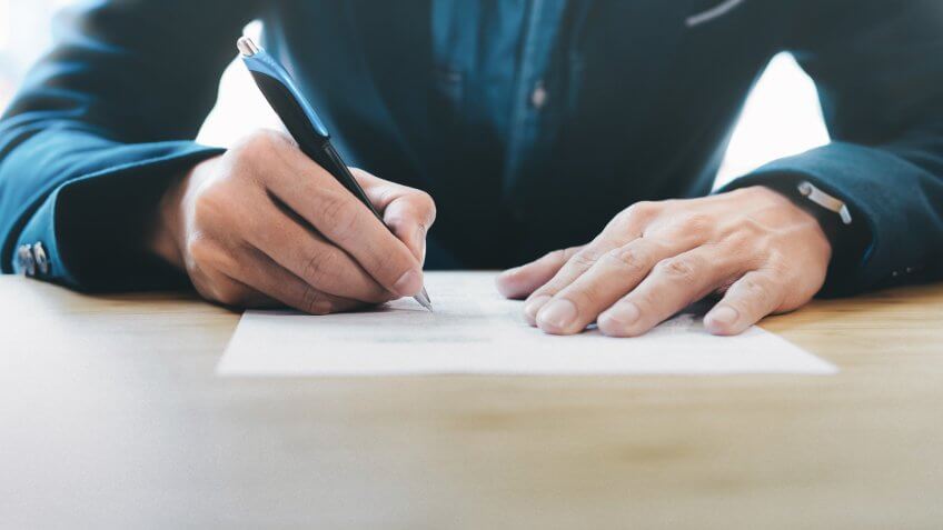 Close up businessman signing contract making a deal.
