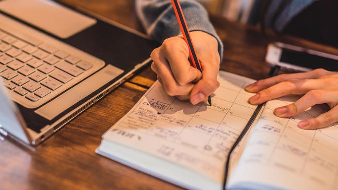 Close-up of young woman taking notes.