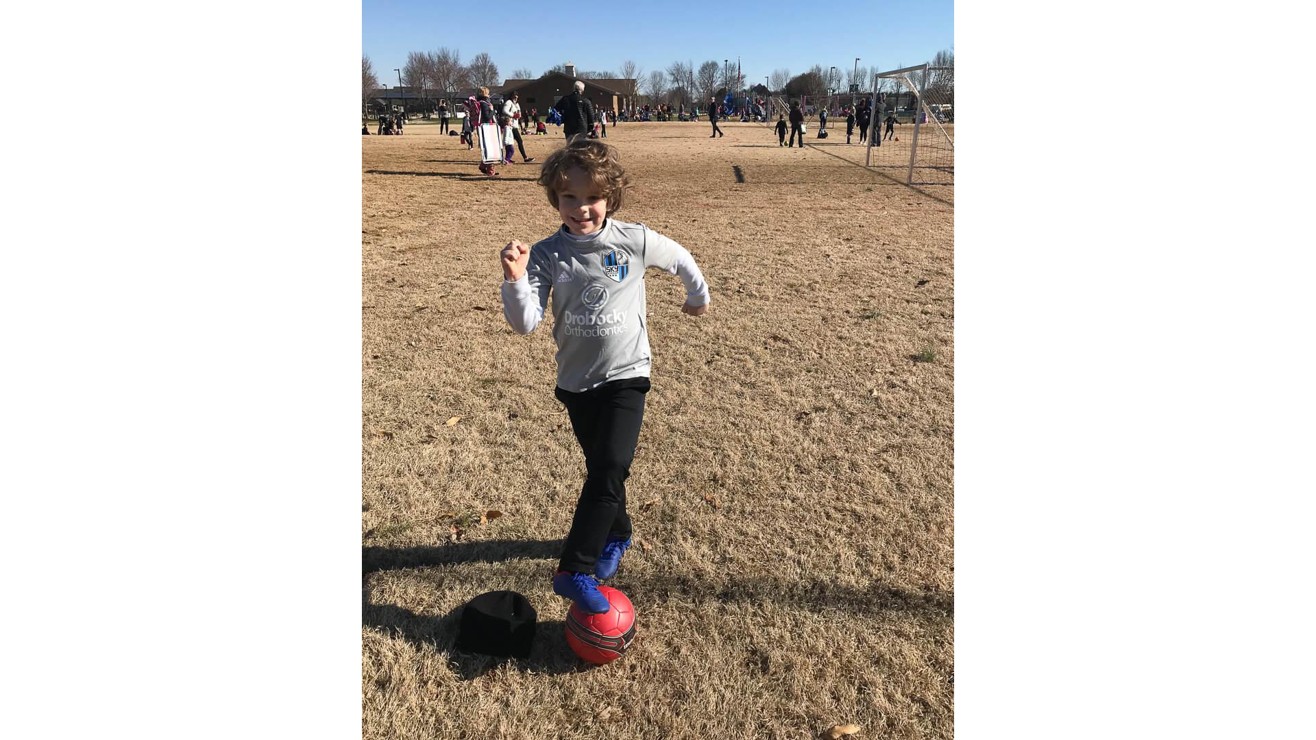 Cameron Huddleston son playing soccer in the park