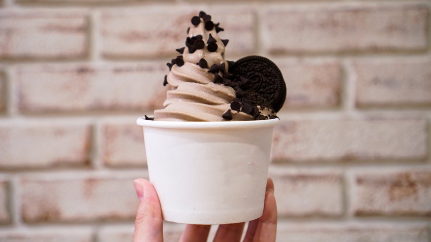Hand holding A cup of Chocolate frozen yogurt.