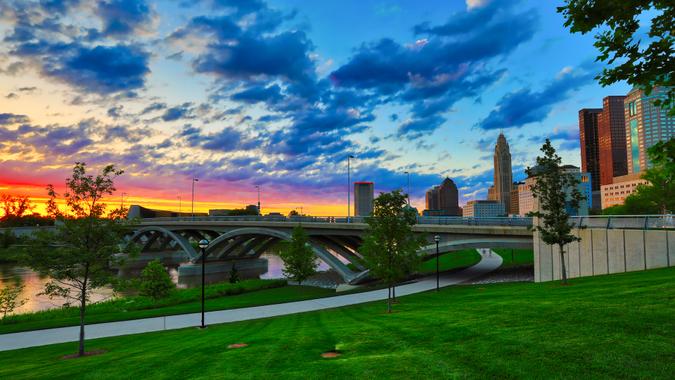 A beautiful sunset in Columbus, Ohio with the Scioto Greenway and the Rich Street Bridge in the foreground.