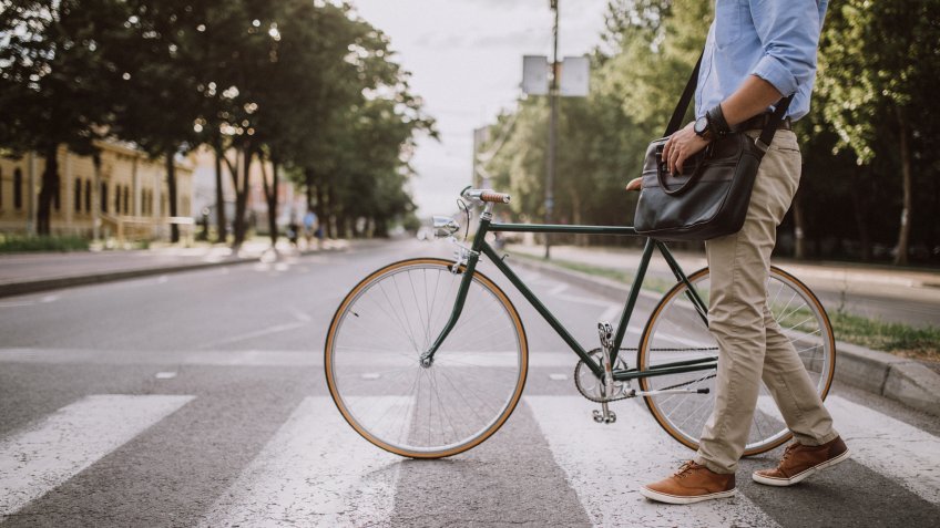 Handsome young businessman with bicycle in the city.