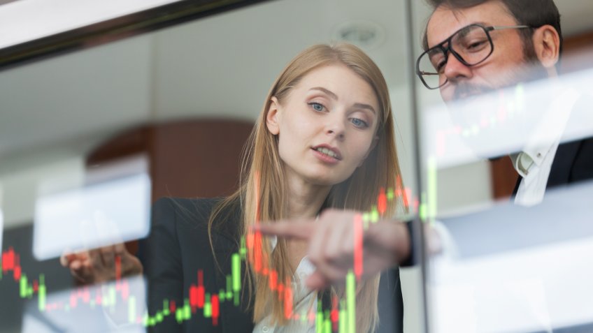 Businesswoman and businessman talking profit on futuristic display.