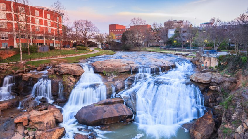 Reedy River Waterfalls run through the middle of downtown Greenville, South Carolina at Falls Park River Walk.