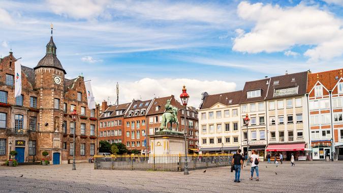 People look at the statue of Jan Wellem located in front of the Old Town Hall on Marktplatz in Old Town Dusseldorf,  North Rhine-Westphalia, Germany.