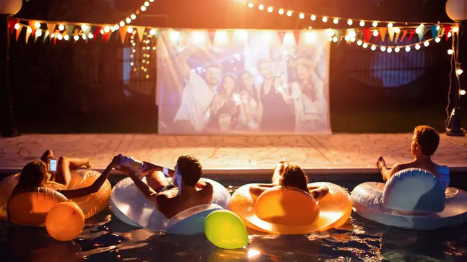 Young friends having pool movie night party.