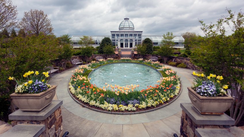 Richmond, Virginia, United States - April 19, 2013: The entrance greeting fountain and the conservatory of the Lewis Ginter Botanical Gardens and Conservatory.