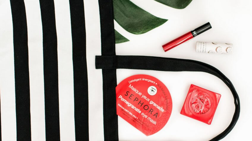 black and white striped bag next to beauty cosmetic items