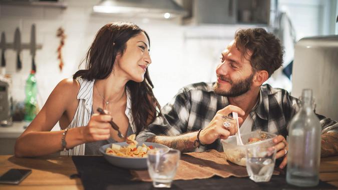 Young couple eating together at home.