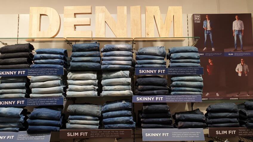 denim store with piles of jeans on shelves