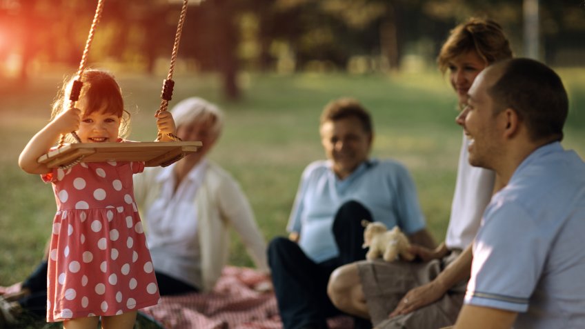 Three generation Family with one child having fun in a park at picnic.