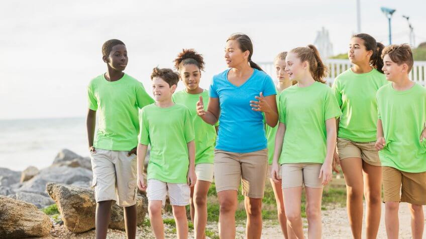 A group of multi-ethnic children and their teacher on a field trip to a marine park.