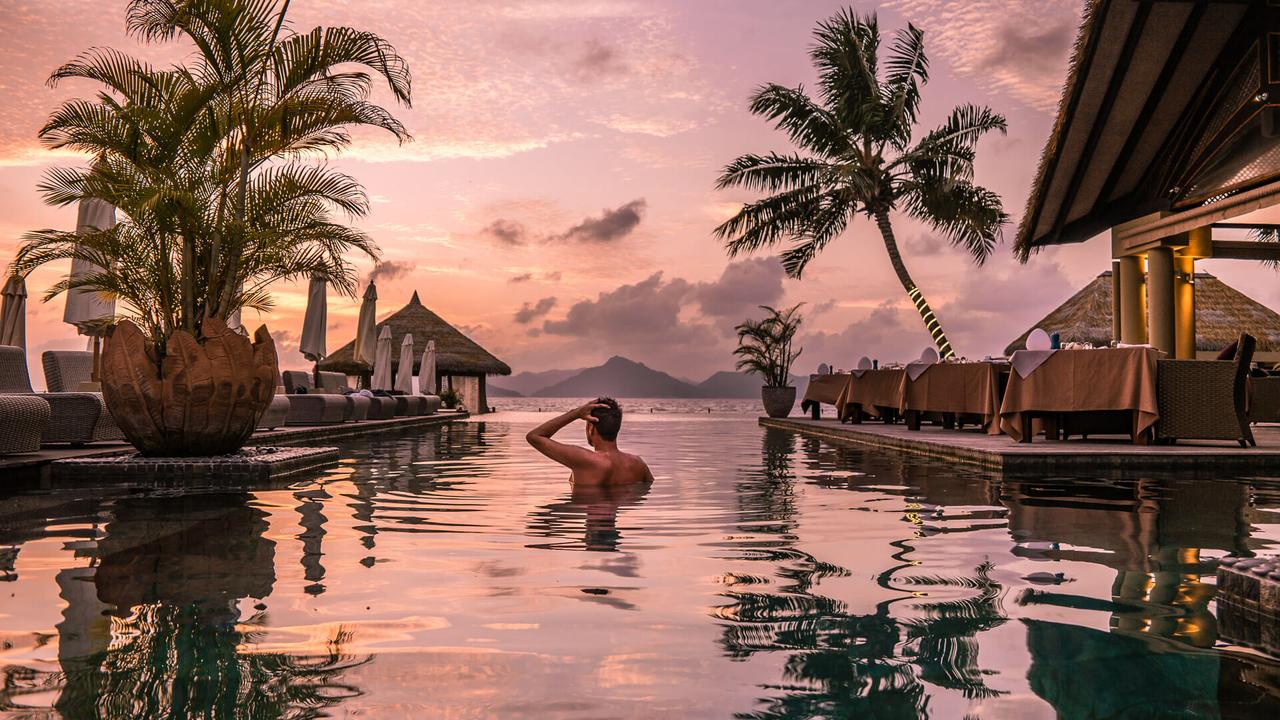 guy swimming in all-inclusive resort vacation