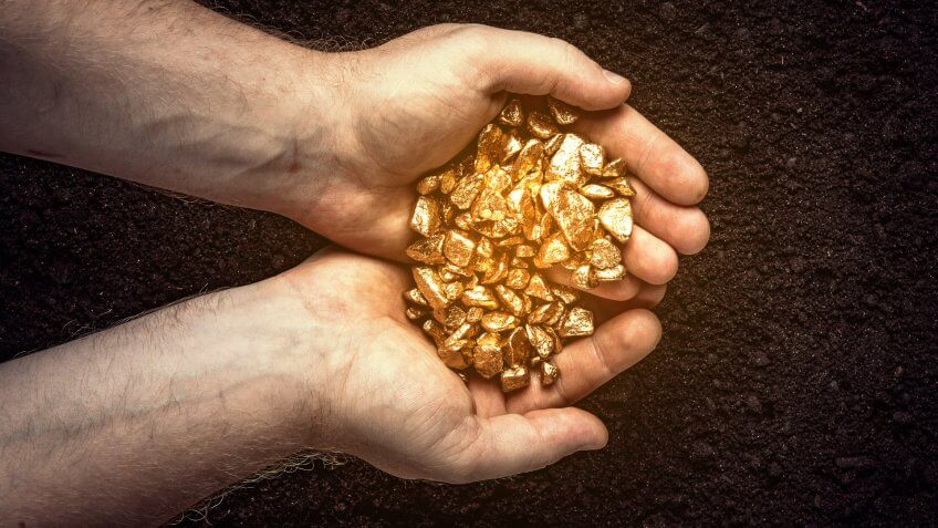 hands holding gold nuggets for investing