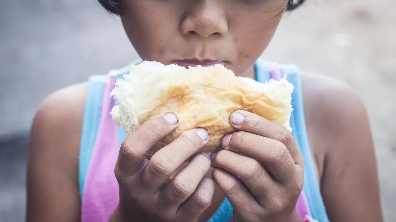 homeless kid eating bread