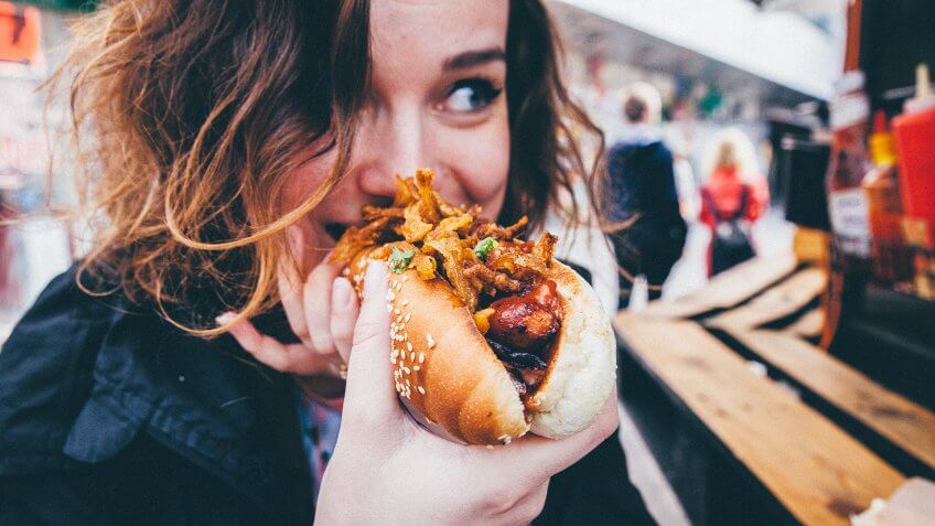 woman eating hotdog at stadium.