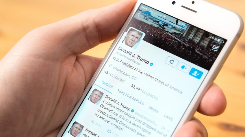 man looking at President Donald Trump twitter account on social