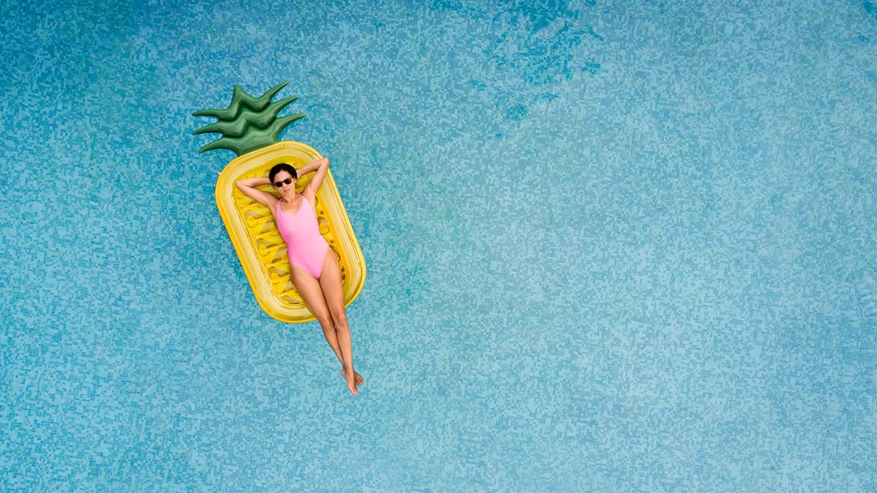 Carefree woman on inflatable pineapple.
