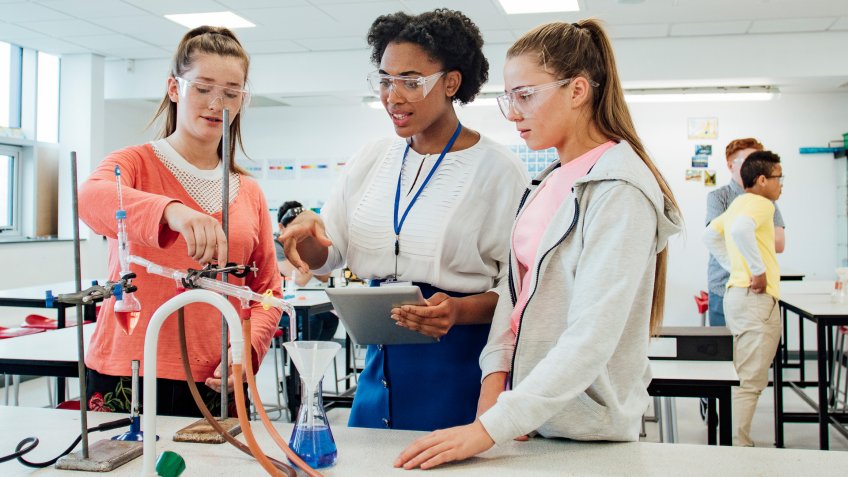 Teenage female students talking with the teacher about the experiment.