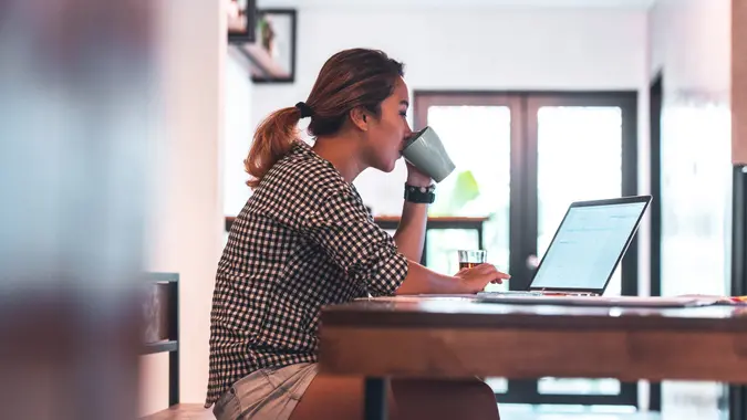 Young woman making monthly budget at table.