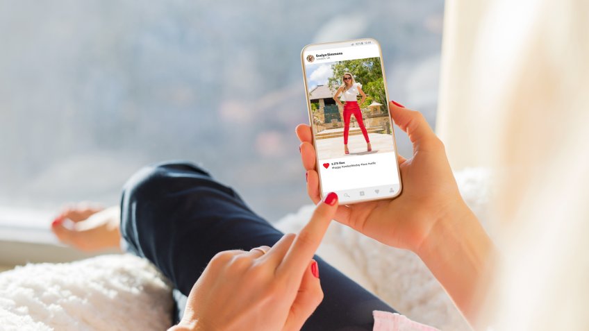woman looking at slightly risque post on Instagram account