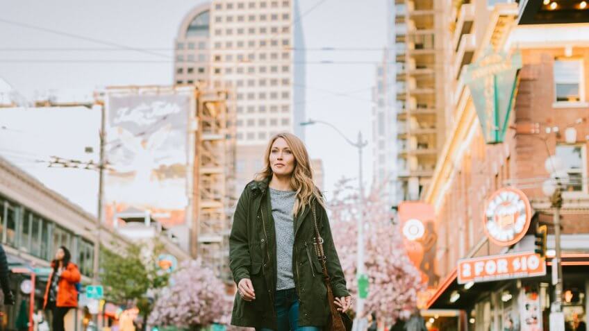 A beautiful and happy woman woman walks around downtown Seattle on a nice day.