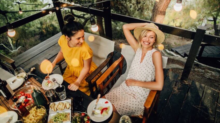 Photo of friends having a summer dinner party outdoors.