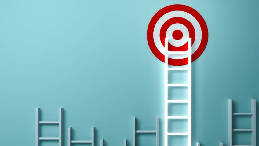 Stand out from the crowd and different creative idea concepts , Longest light ladder glowing and aiming high to goal target among other short ladders on green background with shadows .