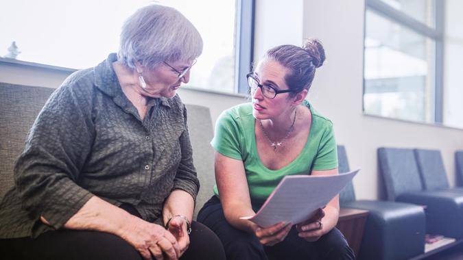 A mature woman in her 70's fills out medical paperwork at the Dr.