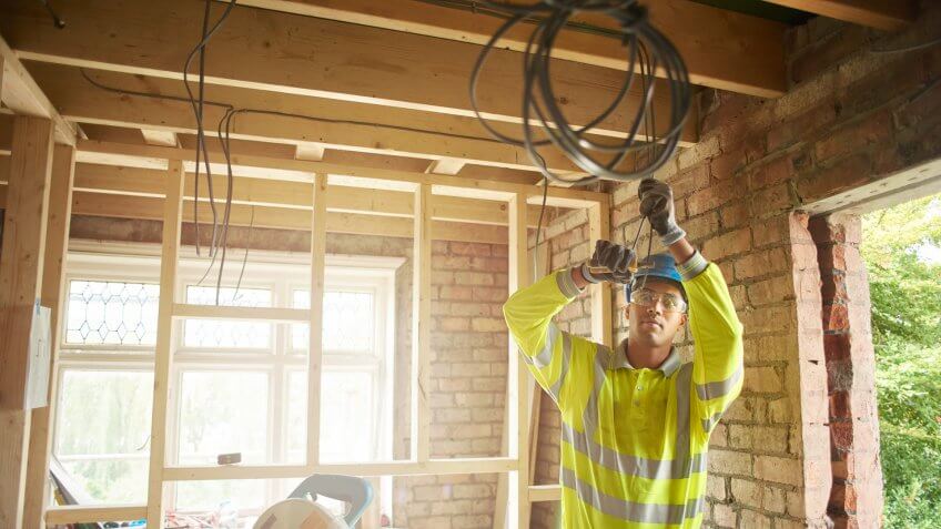 a young male carpenter clipping electrical wires on a first fix.