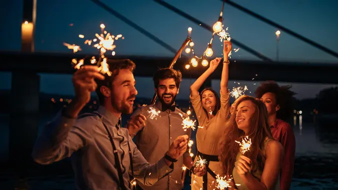 Group of friends celebrating holding sparklers.