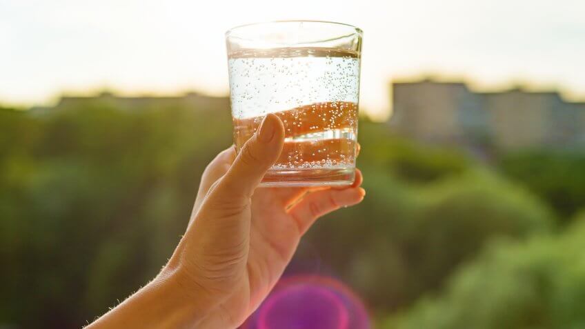 Glass of clear, ecology water in hand.
