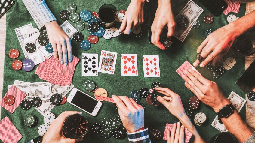 group of friends gambling with cards and poker chips