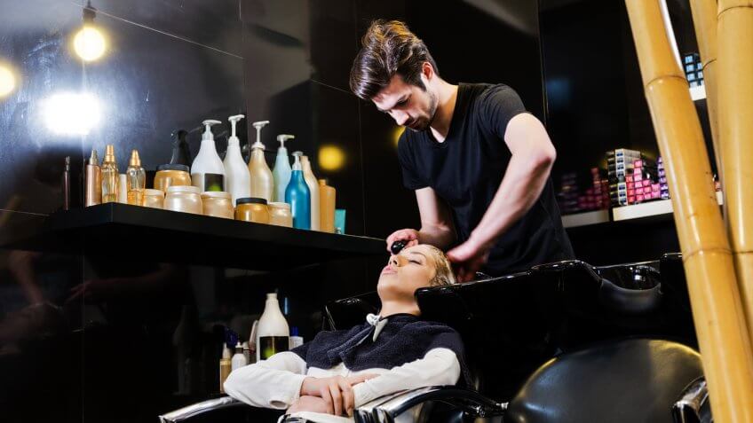 Young woman washing hair in salon ,profile view.