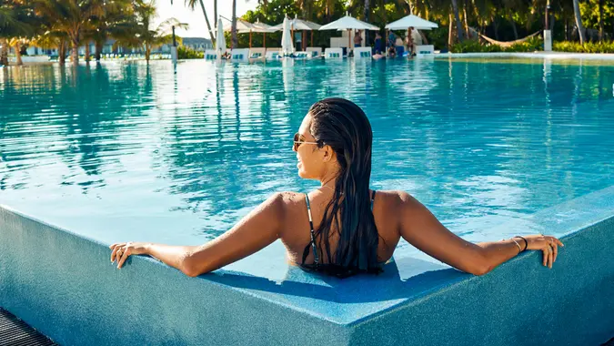 luxury woman relaxing by luxury pool
